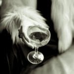 Dłoń kobiety w futrze trzyma elegancki koktajl podczas kolacji