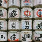 Tradycyjne japońskie beczki sake z kaligrafią ustawione w rzędzie