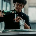 Barman w Buenos Aires nalewa Fernet do szklanki w nowoczesnym barze