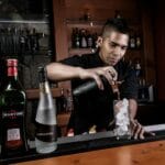 Barman w Limie nalewa koktajl z pisco na lód w barze nocą