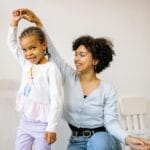 Mama i kilkuletnia córka śmieją się razem w domu