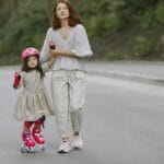 Mama uczy córkę jazdy na rolkach na malowniczej drodze