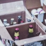 Butelki piwa różnych marek ułożone w otwartych kartonowych pudełkach