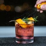 Whisky sour z cytrusami i gałązką rozmarynu w szklance z lodem