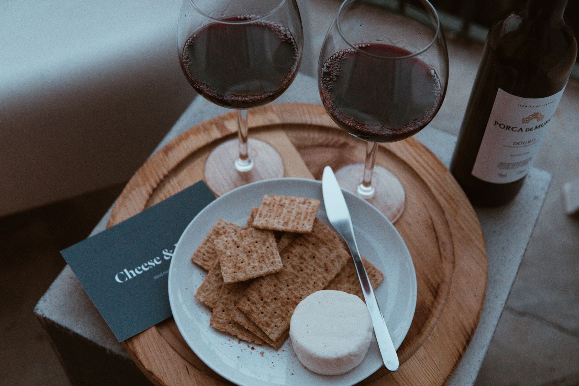 Domowe foodpairing party: jak łączyć sery z winami z Francji, Włoch i Hiszpanii Czerwone wino i sery na rustykalnej desce w eleganckiej aranżacji