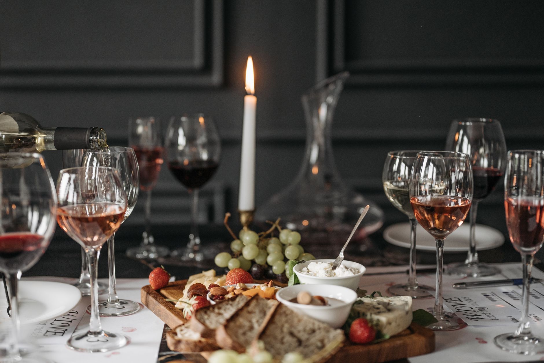 Degustacja wina z deską serów, owocami i świecą w pomieszczeniu
