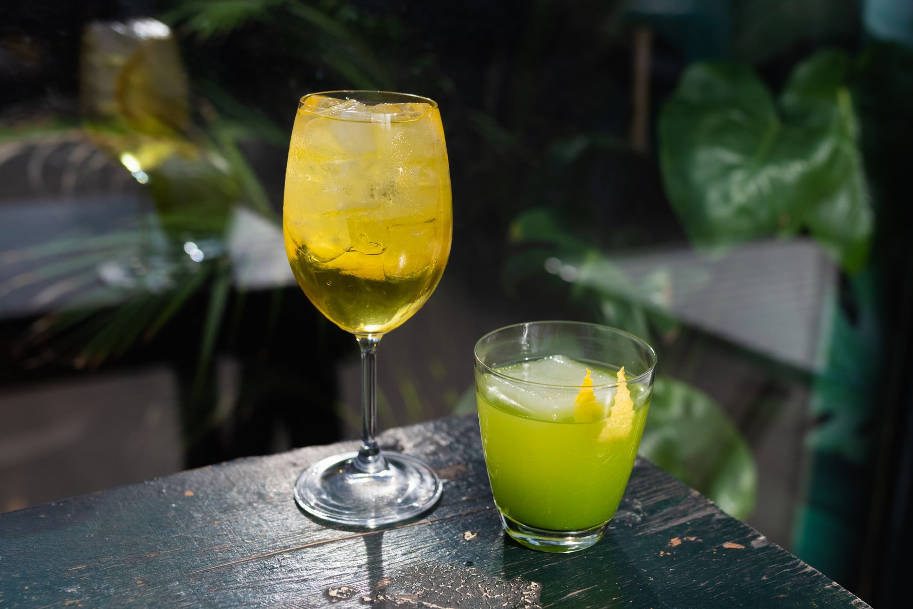 Dwa kolorowe koktajle low ABV z lodem i cytryną na drewnianym stole